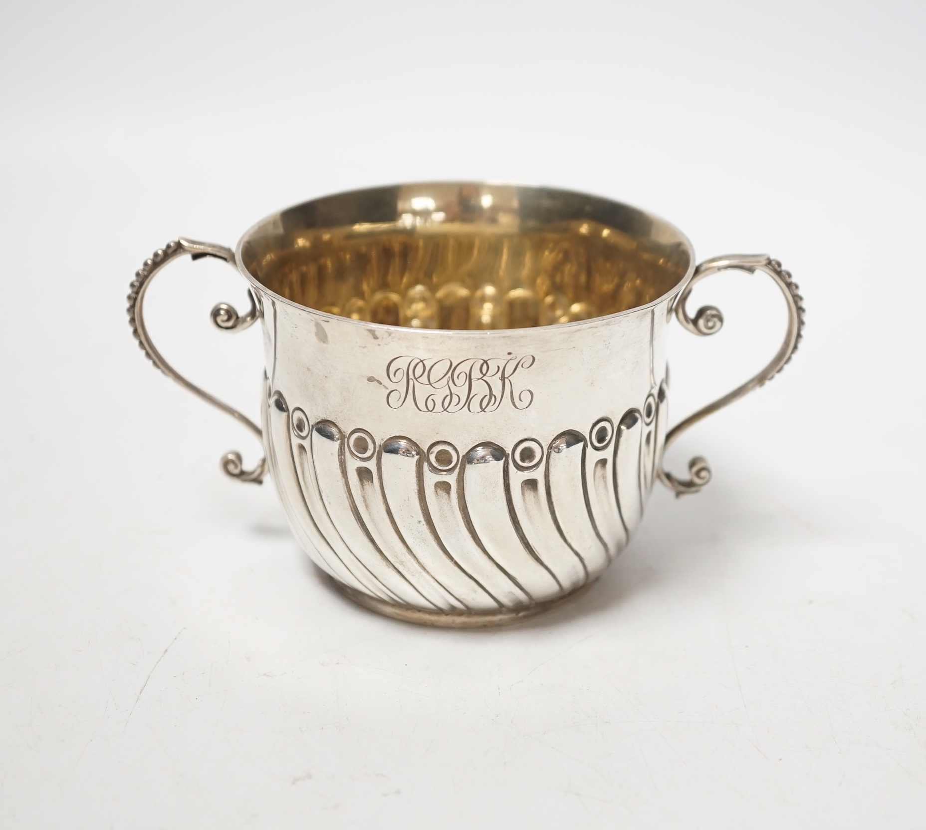 A late Victorian embossed silver porringer, Robert Stebbings, London, 1890, height 7cm, 4.9oz.